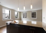 Thumbnail 20 of 39 - a kitchen with a large island with granite countertops at Metro67, Memphis, TN, 38103