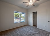 Thumbnail 19 of 23 - A room with a ceiling fan and a window overlooking a street.