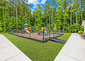 Thumbnail 3 of 6 - A playground with a swing set and slide in the middle of a grassy area.