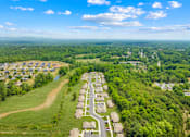 Thumbnail 7 of 7 - A bird's eye view of a residential area surrounded by greenery.