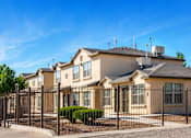 Thumbnail 3 of 6 - A row of houses with a black fence in front.