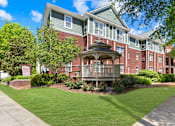 Thumbnail 1 of 13 - A red brick building with a gazebo in the front yard.