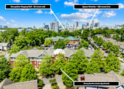 Thumbnail 12 of 13 - A bird's eye view of a residential area with a shopping mall, apartment complex, and a city skyline in the distance.