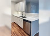 Thumbnail 27 of 35 - a kitchen with white cabinets and a stainless steel dishwasher