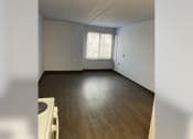 Thumbnail 7 of 22 - an empty living room with white walls and a window