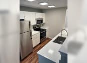Thumbnail 29 of 35 - a kitchen with white cabinets and stainless steel appliances