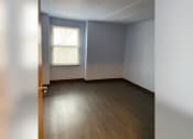 Thumbnail 13 of 22 - an empty room with wood floors and a window