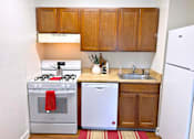 Thumbnail 3 of 17 - A small kitchen with a white refrigerator, a white dishwasher, and a white stove.