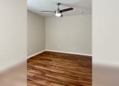 Thumbnail 30 of 35 - a bedroom with a ceiling fan and hardwood floors