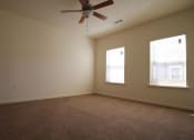 Thumbnail 13 of 16 - an empty living room with a ceiling fan and two windows