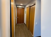 Thumbnail 17 of 22 - a hallway with two doors and a door to a bathroom