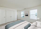 Thumbnail 3 of 10 - A bedroom with a large bed and a window with blinds.