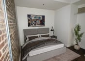Thumbnail 2 of 9 - a bedroom with a bed and a brick wall at Lofts at Union Alley, Tennessee