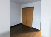 Thumbnail 11 of 22 - an empty room with wood floors and a door to a closet