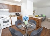 Thumbnail 5 of 25 - A modern kitchen with a glass table and grey chairs.