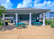 Thumbnail 5 of 33 - a covered patio with picnic tables in front of a building