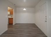 Thumbnail 6 of 33 - an empty living room with a door to a kitchen