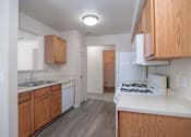 Thumbnail 12 of 33 - an empty kitchen with wooden cabinets and white appliances and a stove top oven