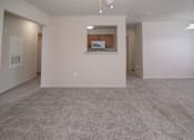 Thumbnail 20 of 33 - an empty living room with a kitchen in the corner