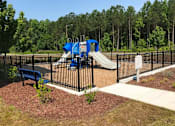 Thumbnail 8 of 9 - a playground with a blue slide and a bench