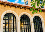 Thumbnail 5 of 16 - A building with two large arched windows and a red tile roof.