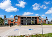Thumbnail 21 of 27 - A large building with a parking lot in front of it.