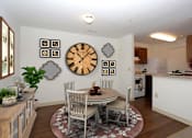 Thumbnail 11 of 19 - a dining room with a table and chairs and a clock on the wall