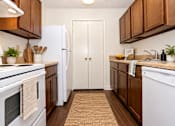 Thumbnail 18 of 50 - A kitchen with white appliances and brown cabinets.