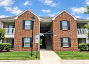Thumbnail 4 of 50 - A red brick building with a blue sign in front.