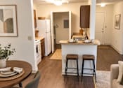 Thumbnail 21 of 50 - A kitchen with a bar stool and a fridge.