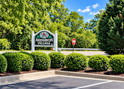 Thumbnail 9 of 50 - A sign for Audubon Village stands in front of a parking lot.