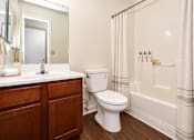 Thumbnail 35 of 50 - A white toilet sits next to a white sink in a bathroom.