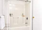 Thumbnail 36 of 50 - A white bathroom with a white tub and a white towel hanging on the side.