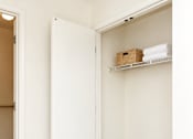 Thumbnail 37 of 50 - A white closet with a shelf and a basket on it.