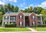 Thumbnail 40 of 50 - A red brick apartment building with a green lawn in front.
