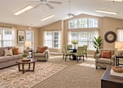 Thumbnail 10 of 50 - A living room with a sofa, chairs, a dining table, and a ceiling fan.