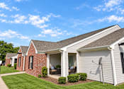 Thumbnail 43 of 50 - A house with a red brick exterior and a white garage door.