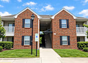 Thumbnail 42 of 50 - A red brick building with a blue sign in front.