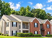 Thumbnail 47 of 50 - A row of townhouses with a green tree in the background.