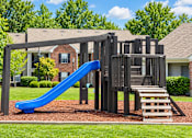 Thumbnail 48 of 50 - A playground with a blue slide and a wooden structure.
