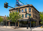Thumbnail 1 of 7 - A street view of a city with a traffic light and a building with a sign that reads "The Standard".
