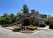 Thumbnail 1 of 4 - a house with a driveway and landscaping in front of it