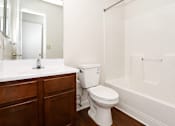 Thumbnail 15 of 19 - A white toilet sits in a bathroom next to a sink and a bathtub.