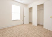 Thumbnail 16 of 19 - A room with a carpeted floor and a window.