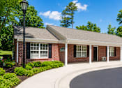 Thumbnail 4 of 19 - A small red brick building with a black lamp post in front.