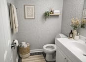 Thumbnail 16 of 16 - A white toilet sits in a bathroom next to a white sink.