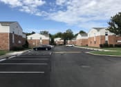Thumbnail 1 of 17 - an empty parking lot in a neighborhood with brick buildings