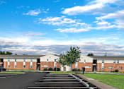 Thumbnail 21 of 25 - A parking lot in front of a building with a clear blue sky above.