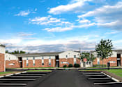 Thumbnail 23 of 25 - A parking lot in front of a brick building with a red stop sign.