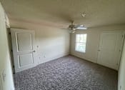Thumbnail 10 of 15 - A room with a ceiling fan and carpeted floor.